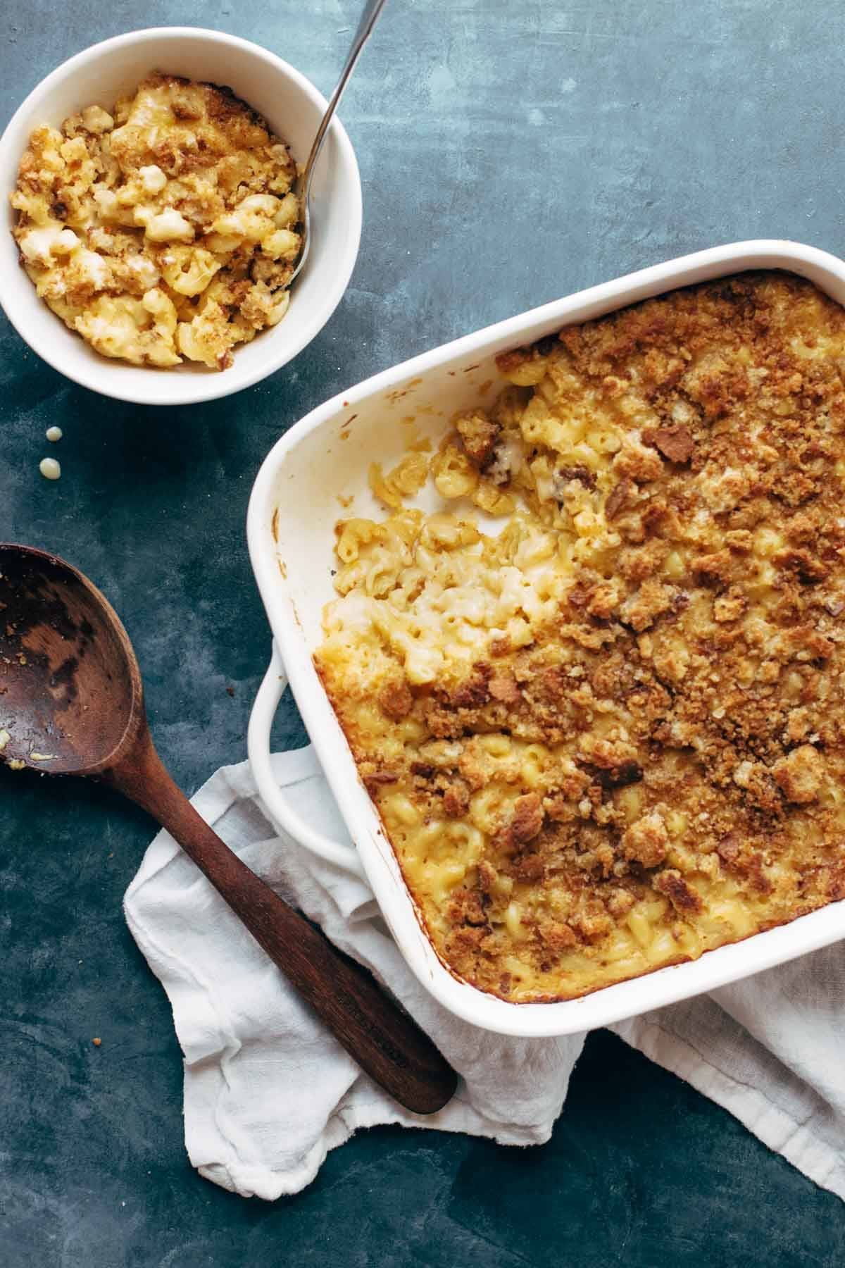 Baked Mac and Cheese in a dish with a wooden spoon and a bowl of mac and cheese on the side