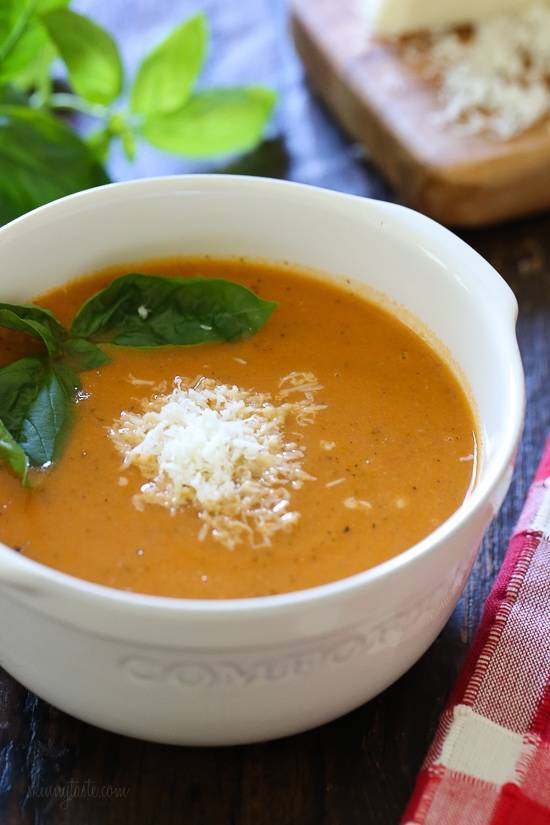 A bowl filled with tomato soup and cream in the middle.