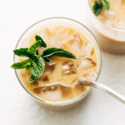 Vanilla mint iced coffee in two glasses, one with a metal straw.